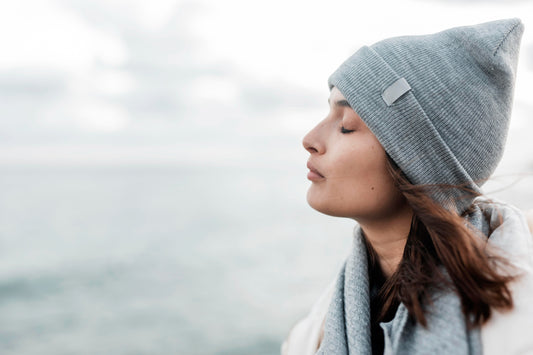 Femme avec un bonnet en hiver qui ferme les yeux